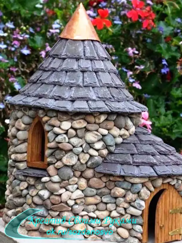 從塑料瓶和石頭的城堡。花園裝飾或小屋的原始想法。