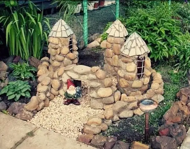 Castello da bottiglia di plastica e pietre. Idea originale per decorazioni da giardino o cottage.