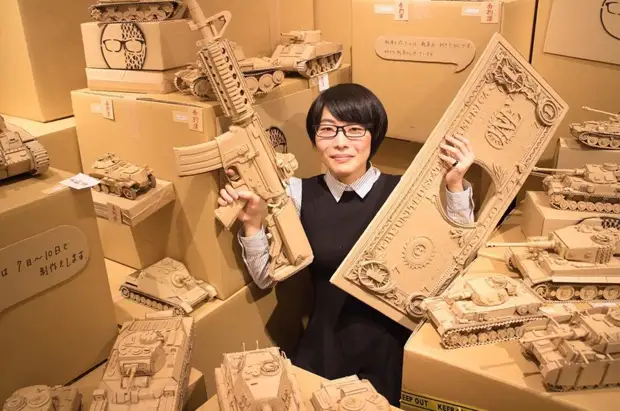 그 소녀는 탱크, 음식 및 기타 놀라운 조각 조각, 골판지 상자에 오래 된 골 판지 상자를 켭니다.