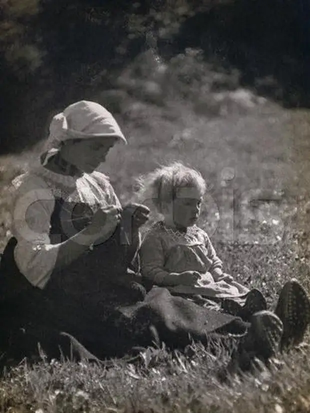 Ca. 1931 --- Moeder en dogter sit in 'n weiland. Die vrou breek. --- Image by? Alinari Argief / Corbis