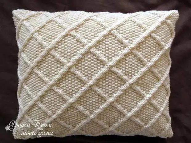 Gestrickte Kissenbezüge auf Sofakissen mit Stricknadeln