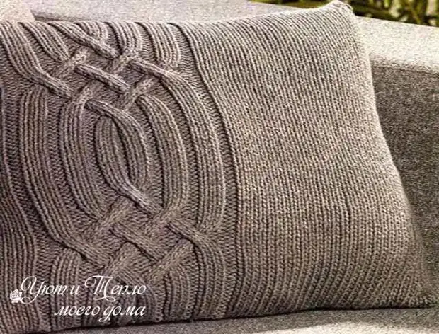 Pillowcases knitted kwenye mito ya sofa na sindano za knitting.