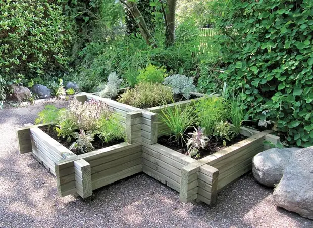 Una cama de varios niveles limpia con una cerca de madera es perfecta para cualquier parcela de jardín.